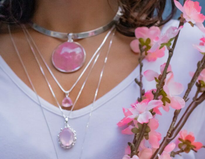 Woman wearing wholesale sterling silver jewelry featuring genuine gemstone rose quartz pendants